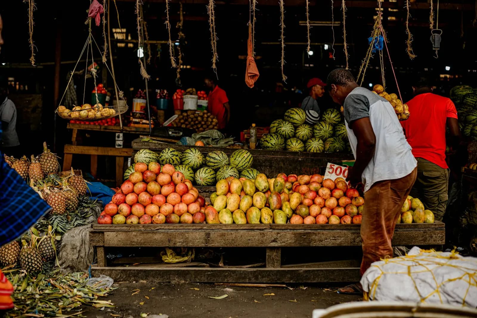 A trader standing at a fruit and vegetable stall