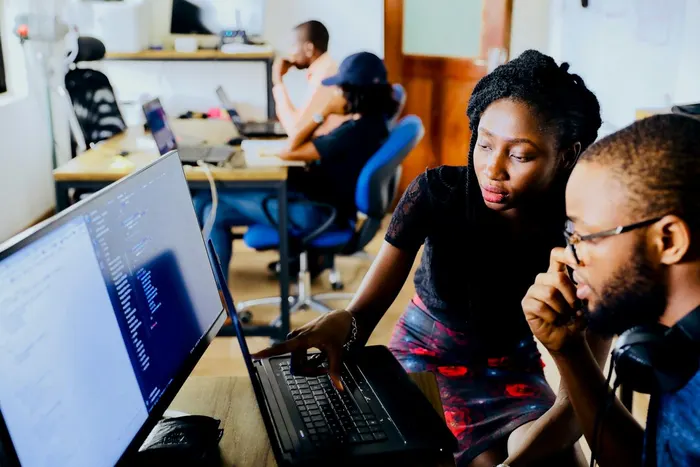 Two developers working together at a monitor