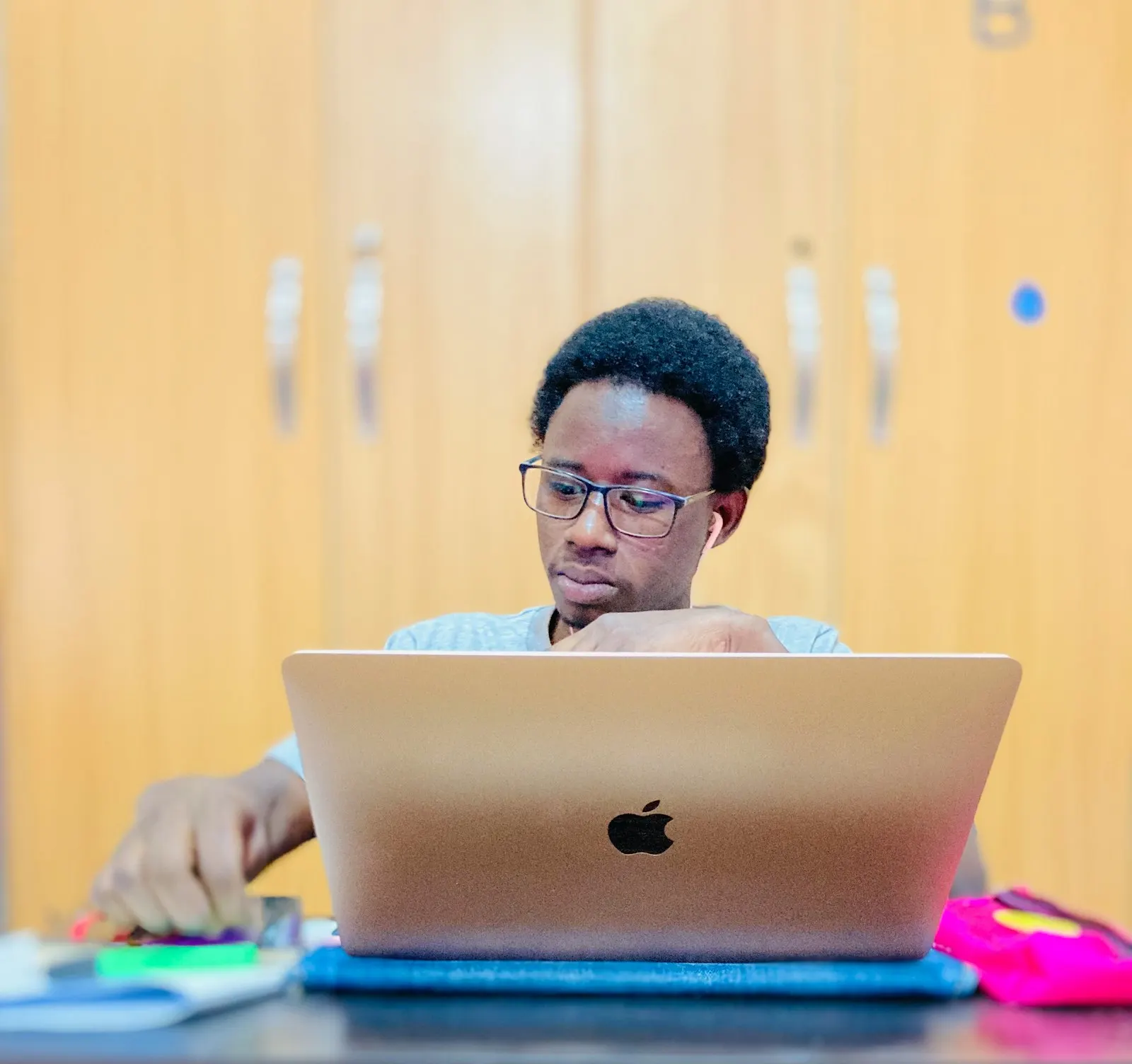 A young man working on a laptop at a desk