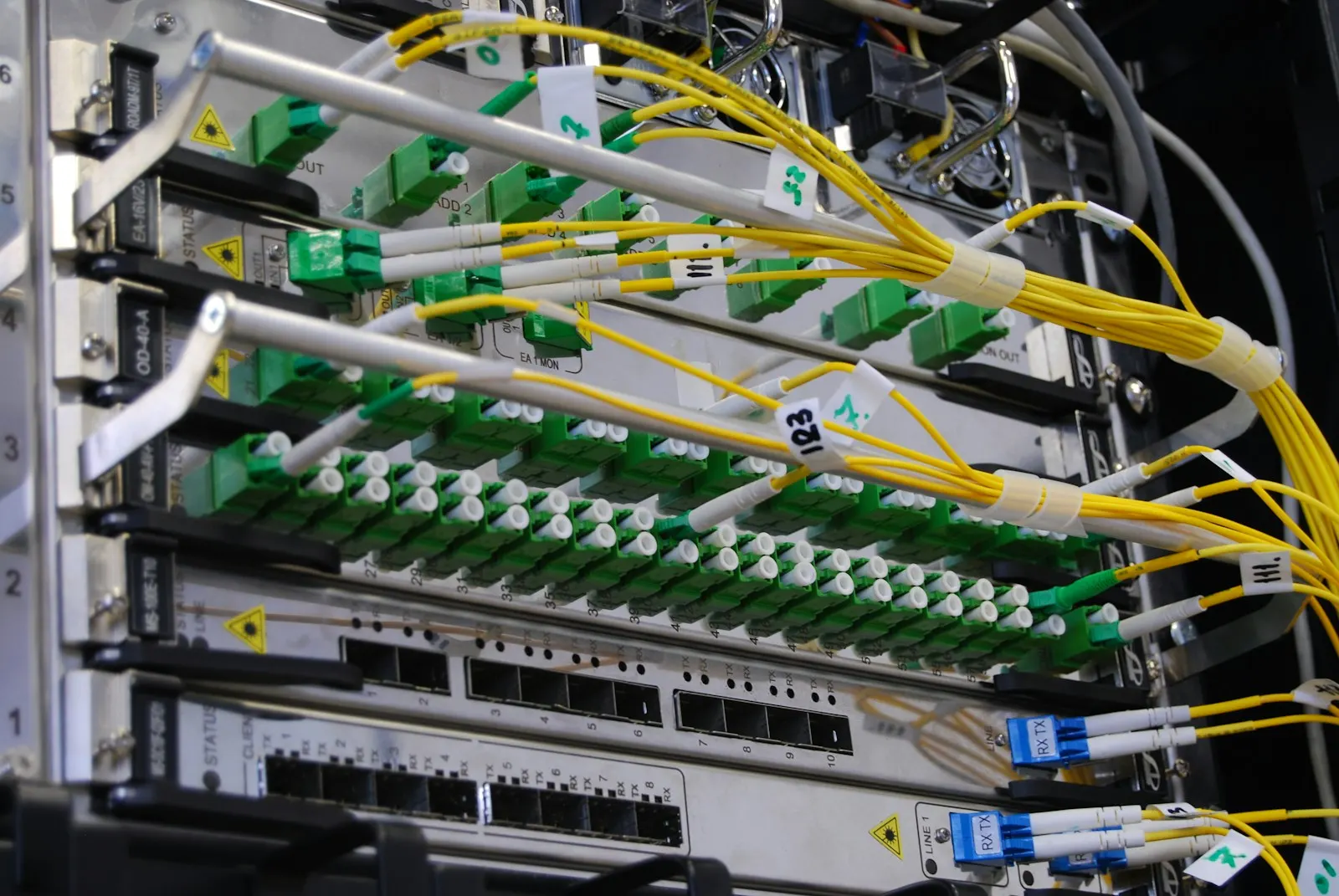 Fibre-optic cables plugged into a network switch in a server rack